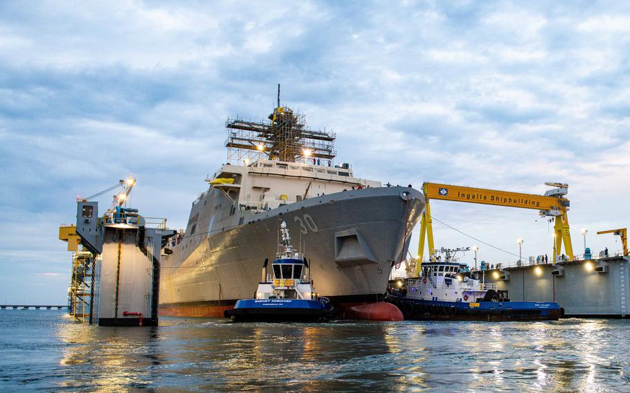 A large amphibious trasnport dock ship sits in a harbor in Mississippi.