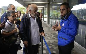 A U.S. consular official explains to people with scheduled visa document submissions that their appointments were canceled due to Colombian President Gustavo Petro's refusal to accept repatriation flights of Colombian citizens from the U.S., at a U.S. Embassy Applicant Service Center in Bogota, Colombia, Monday, Jan. 27, 2025. (AP Photo/Fernando Vergara)