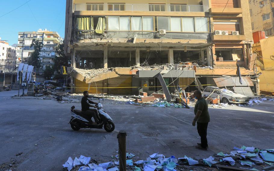 Citizens inspect the damage after an Israeli airstrike struck a branch of the Al-Qard Al-Hassan finance group in Beirut’s southern suburbs.