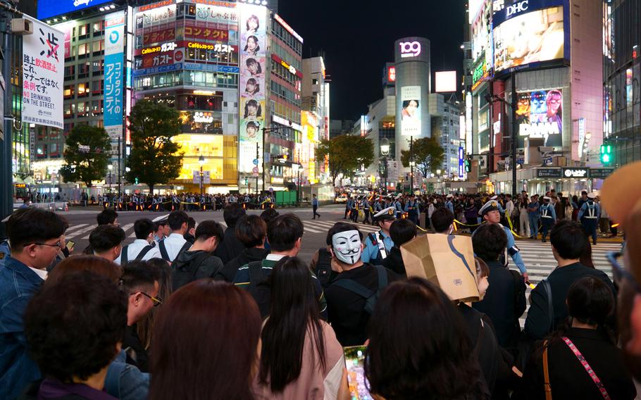 Police control crowds waiting to cross the iconic scramble intersection in Tokyo’s Shibuya ward, Tuesday, Oct. 31, 2023.