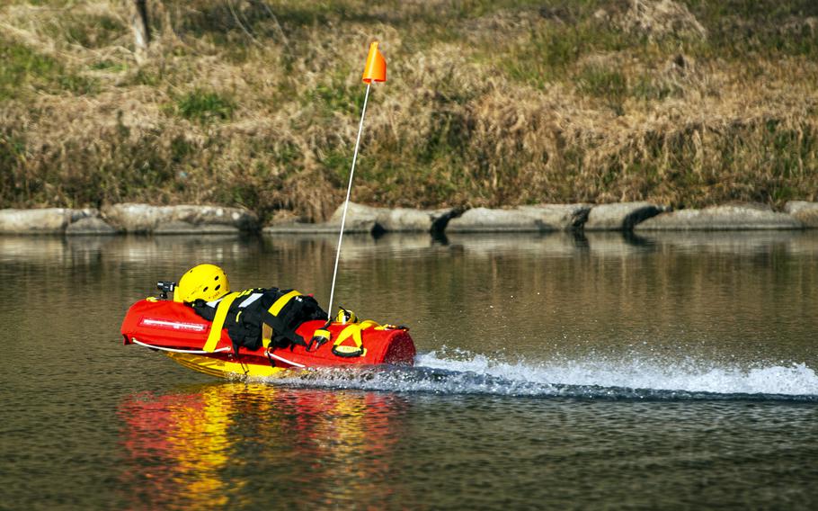Firefighters demonstrate EMILY — the Emergency Integrated Lifesaving Lanyard — at the Nishiki River in Iwakuni, Japan, on Feb. 13, 2024.