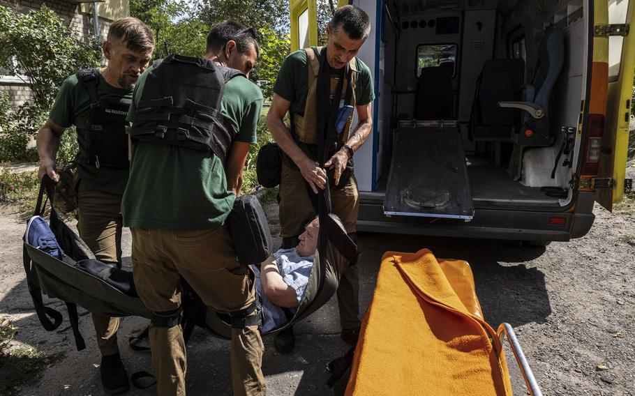 Volunteers used a tarp to carry Oleksandr downstairs to a waiting ambulance.