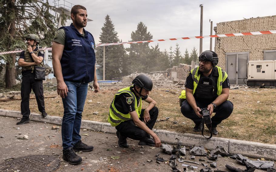 Police and prosecutorial staff on Sept. 2 collect bomb fragments as evidence of a Russian glide bomb strike. 