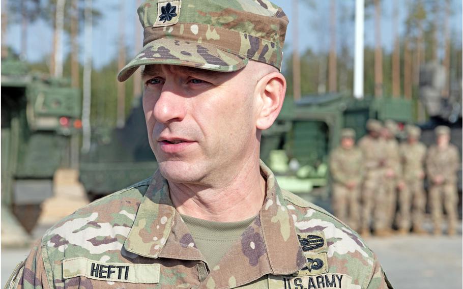 An Army officer in camouflage uniform and hat is seen from the chest up.