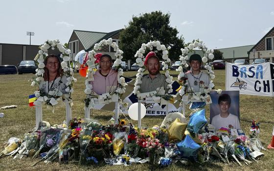 A poster with images of shooting victims from left, Cristina Irimie, Mason Schermerhorn, Richard Aspinwall and Christian Angulo is displayed at a memorial outside Apalachee High School, Tuesday, Sept. 10, 2024, in Winder, Ga.  (AP Photo/Charlotte Kramon)