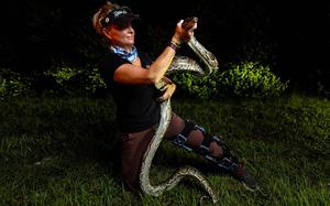 Python Huntress Amy Siewe holds an invasive 10-foot Burmese Python, originally caught by her colleague Harold Antonio Rondon-Mena, during a hunting trip down Tamiami Trail on Sept. 5, in Miami.  Siewe has caught over 600 pythons herself since trading a real estate career in Indiana to become a professional python hunter five years ago. Guiding, however, has proven far more lucrative for her than just catching and trapping snakes as a state-certified python hunter so she made it her full-time business in the last two years. 