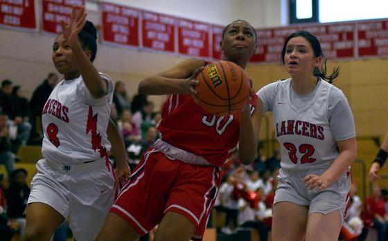 Kaiserslautern's Hazel Sanders goes up for a layup as Lakenheath's Amiah Morgan, left, and Isabella Herman chase during a Dec. 14, 2024, game at Kaiserslautern High School in Kaiserslautern, Germany.