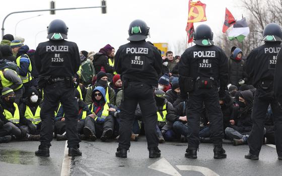 Police officers stand guard during a demonstration ahead of the AfD's national party conference, in Riesa, Germany, Saturday, Jan. 11, 2025. (Jan Woitas/dpa via AP)