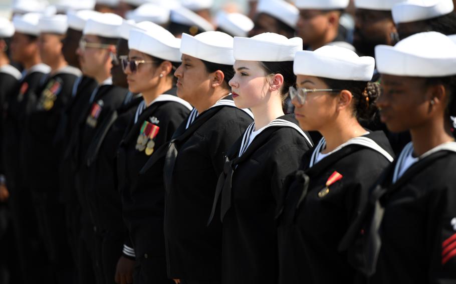 Sailors stand by to man their ship during a commissioning ceremony