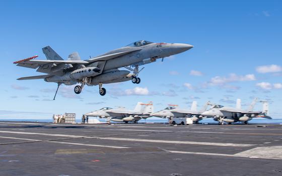 An F/A-18E Super Hornet, makes an arrested gear landing on the aircraft ...