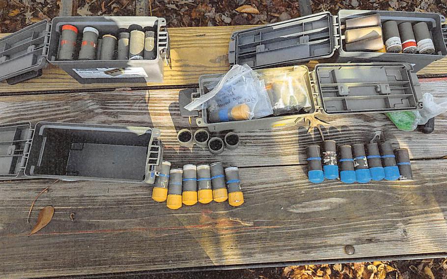 An array of explosives are seen on a wooden bench of table.