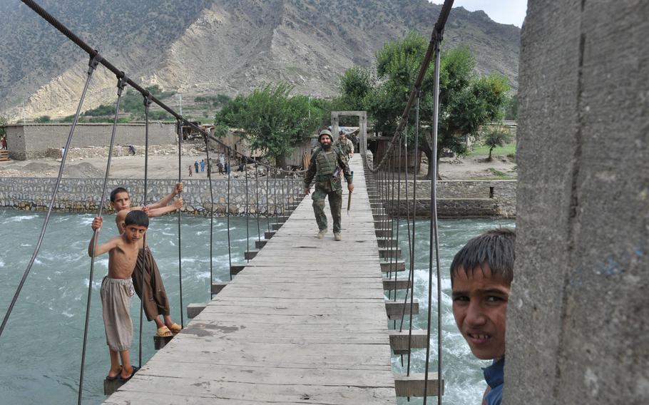 An Afghan National Army solider walks across the goat bridge over the Pech River, returning from a patrol to villages near Combat Outpost Michigan.