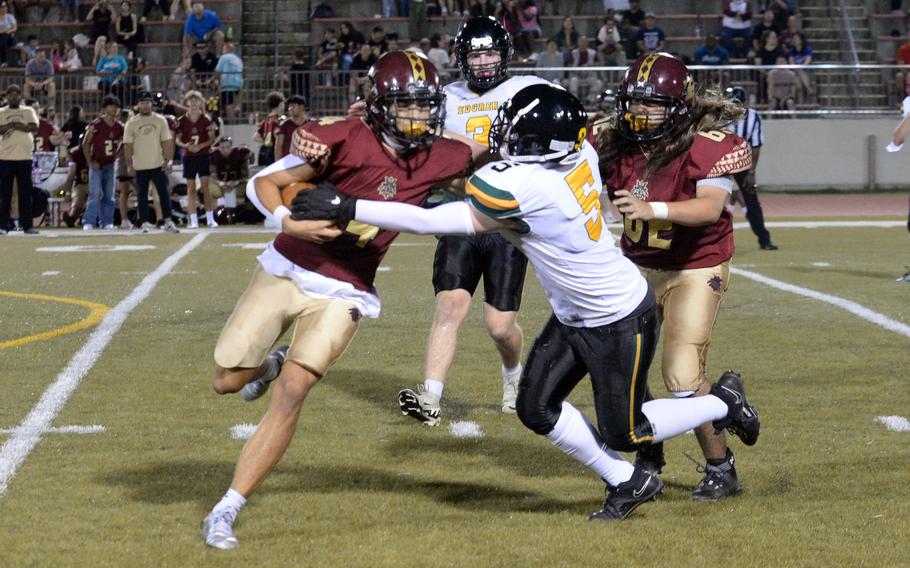 Edgren defender Ethan Mercado tries to strip the ball from Perry quarterback Jordan Burford.