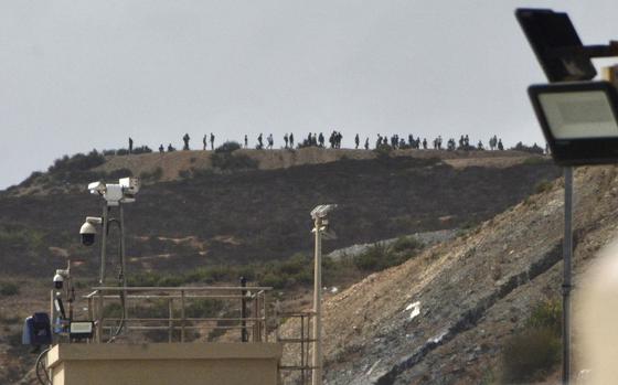 People thought to be migrants stand on top of hill at the Tarajal border in the Spanish enclave of Ceuta, Sunday,  Sept. 15, 2024. (Antonio Sempera/Europa Press via AP)