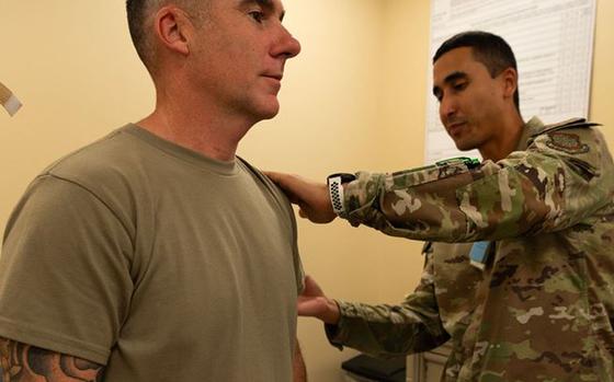 Photo Of Chief Master Sgt. Raun Howell receives a flu shot from Tech. Sgt. Orlando Navarro.