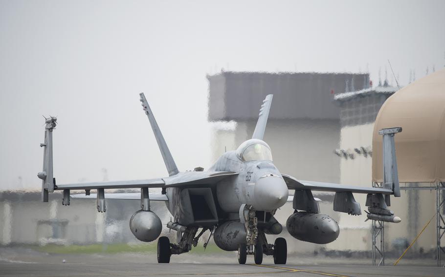 A fighter aircraft is driven along a tarmac.