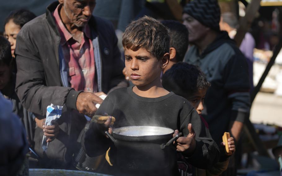 A Palestinian child queues for food