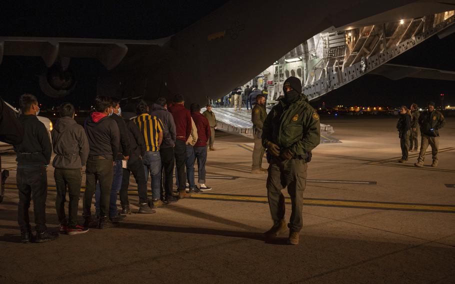 U.S. Customs and Border Protection agents load illegal immigrants onto a C-17 Globemaster III 