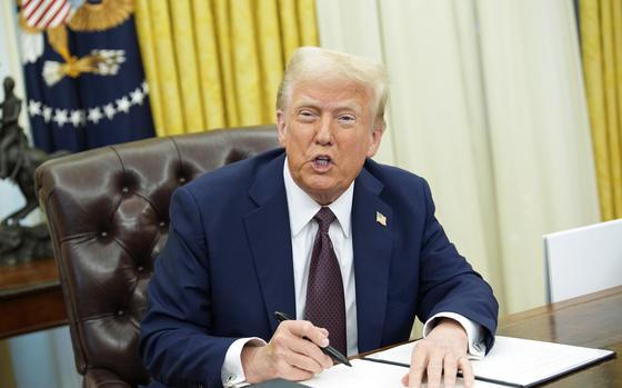 U.S. President Donald Trump signs executive orders in the Oval Office.