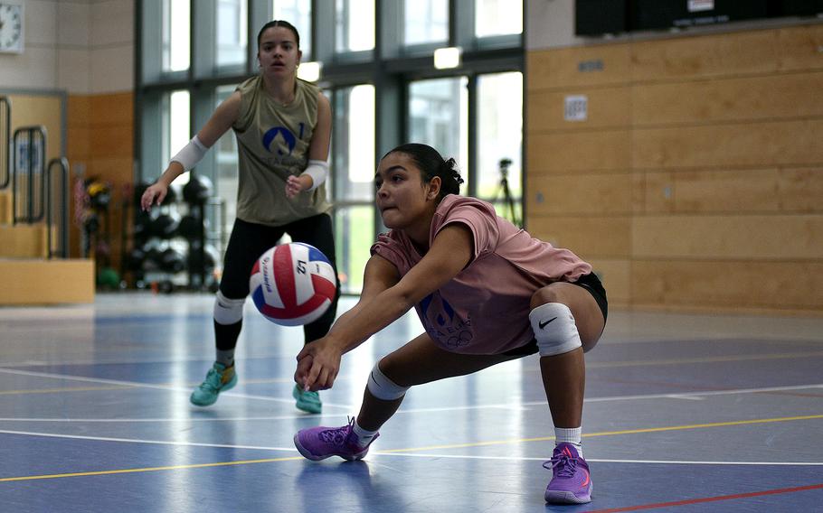 Ansbach junior Victoria Ortiz-Cardenas of the Pink team digs a ball while teammate Marisa Branch of Kaiserslautern watches during the 2024 DODEA-Europe All-Star volleyball matches on Nov. 9, 2024, at Ramstein High School on Ramstein Air Base, Germany.