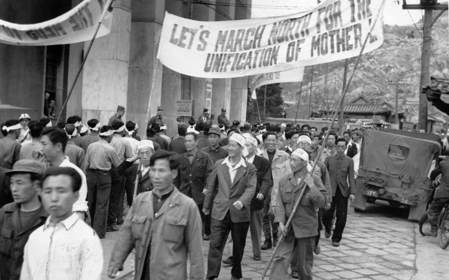 Hundreds of South Koreans march through the streets with banners