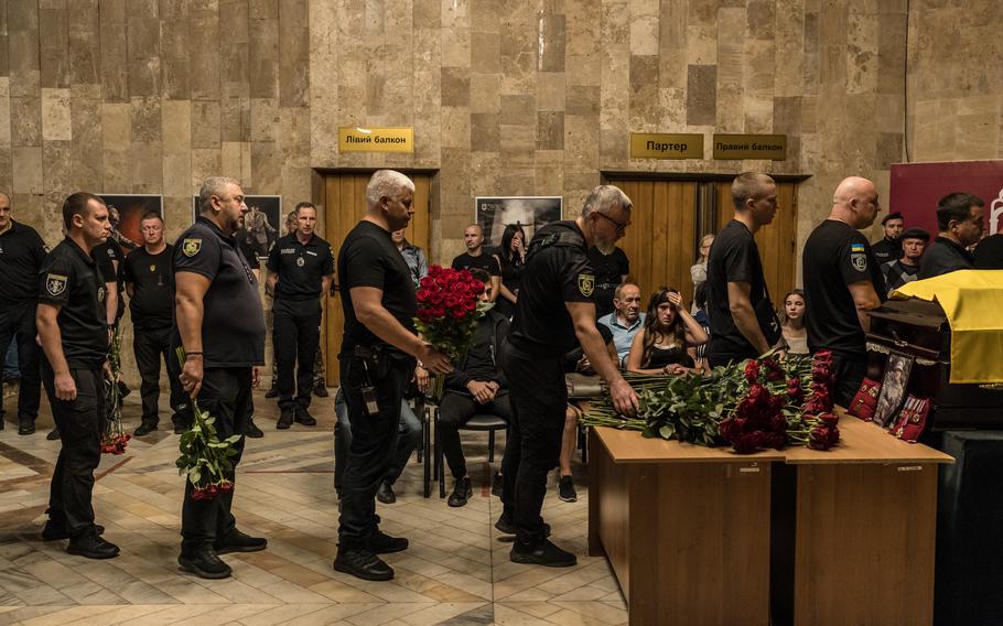 Colleagues lay flowers at the funeral of senior police inspector Oleksandr Popovych