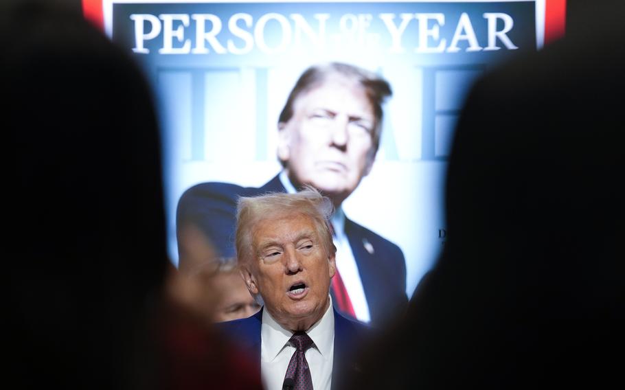 President-elect Donald Trump speaks in front of a Time magazine Person of the Year poster that depicts him.