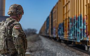 A U.S. soldier from the Georgia National Guard conducts a visual inspection of a passing train traveling from Mexico to the U.S. to detect illegal crossings of the border in Uvalde, Texas on Feb. 12, 2025. U.S. Northern Command is working together with the Department of Homeland Security to augment U.S. Customs and Border Protection along the southern border with additional military forces. This initial deployment of more than 1,600 active-duty personnel brings the total military Title 10 forces along the border to approximately 4,000 personnel. (U.S. Army photo by Sgt. 1st Class Andrew Sveen)