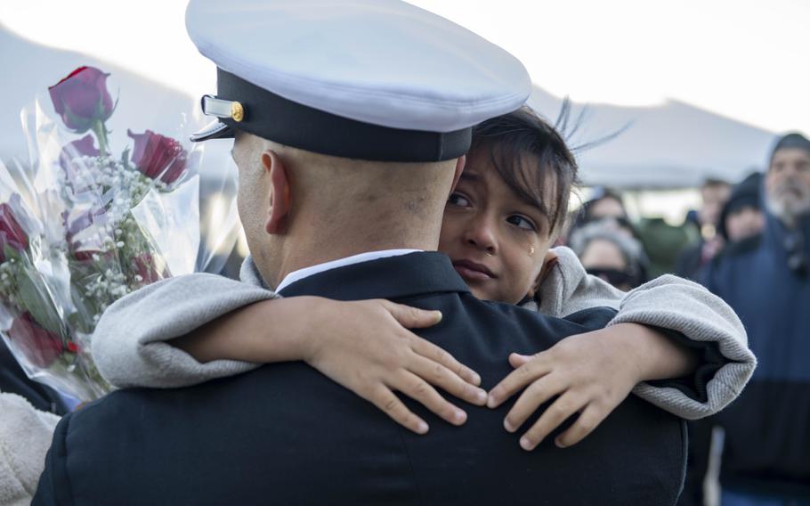 A sailor embraces a tearful loved one.