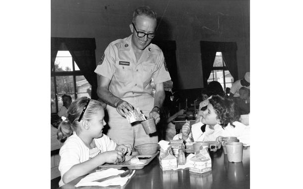 HED: Get milk, 1960: 

Seoul, South Korea, September 1960: Sgt. First Class Bill Thompson, manager of the cafeteria at Seoul High School, pours milk for two of the grammar school students who lunch there every day. The children are Elizabeth Gault (left) and Ellen Finn.

Looking for Stars and Stripes’ historic coverage? Subscribe to Stars and Stripes’ historic newspaper archive! We have digitized our 1948-1999 European and Pacific editions, as well as several of our WWII editions and made them available online through https://starsandstripes.newspaperarchive.com/

META TAGS: DODDS; DODEA; school; education; first day of school; food; school cafeteria; military family; students; girl