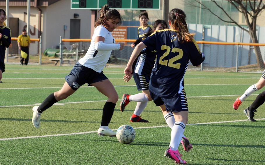 Osan American's Clarice Lee prepares to boot the ball upfield against Cheongna Dalton defenders during Friday's Korea girls soccer match. Lunn scored a hat trick and the Cougars won 4-0.