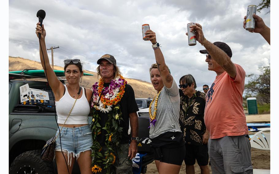 Family and friends of Carole Hartley raise their drinks to honor her and her longtime partner, Charles Paxton, second from left, during a celebration of Hartley's life at Ukumehame Beach near Lahaina, Hawaii. 