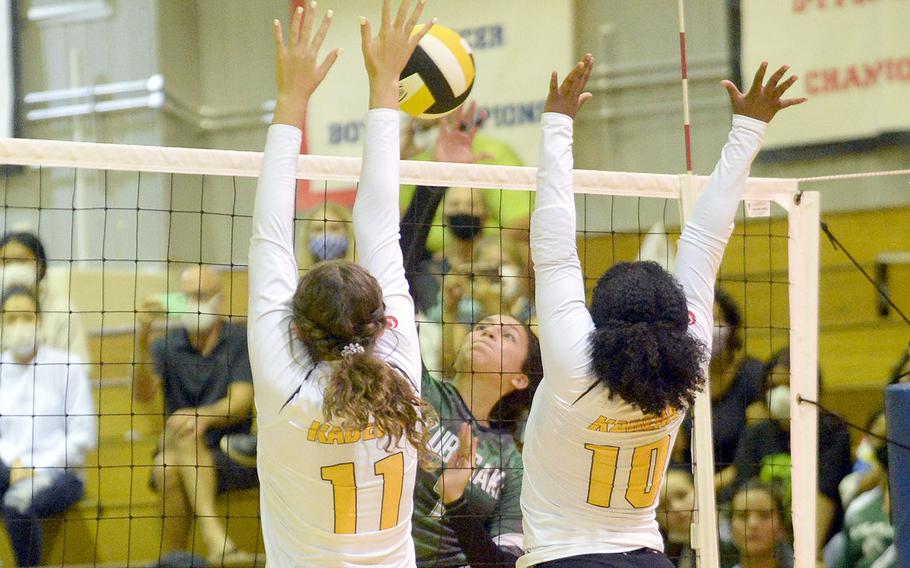 Kubasaki's Sophia Grubbs spikes against the double block of Kadena's Presley Pearce and Kaya Castle during Thursday's Okinawa volleyball match. The Dragons beat the Panthers in straight sets for the 11th time this season.
