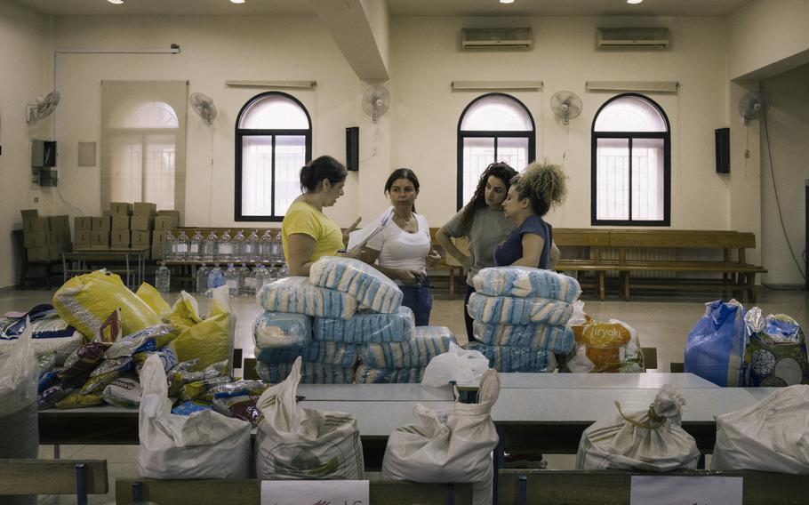 Volunteers at St. George’s church prepare packages of food for people who have decided to stay in Qlaaya, Lebanon. 