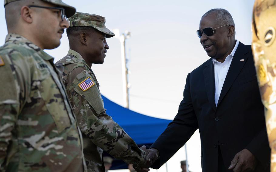 Secretary of Defense Lloyd Austin shakes hands with soldiers at Yokohama North Dock.