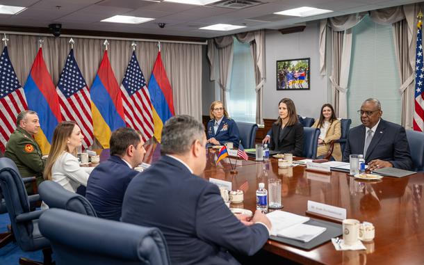 Two rows of people sit across each other on a table.