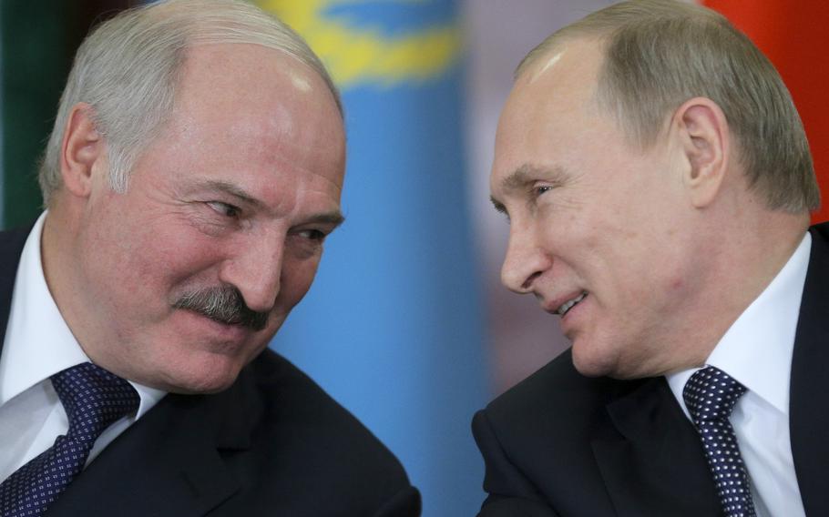 Russian President Vladimir Putin, right, and his Belarus counterpart, Alexander Lukashenko, talk at an economic summit in the Kremlin, in Moscow, Russia.