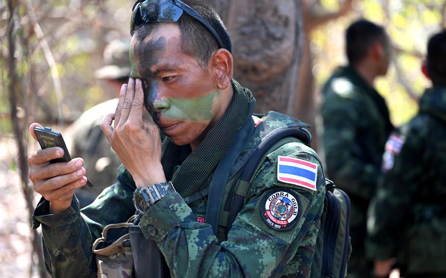 A Thai soldier applies face paint.