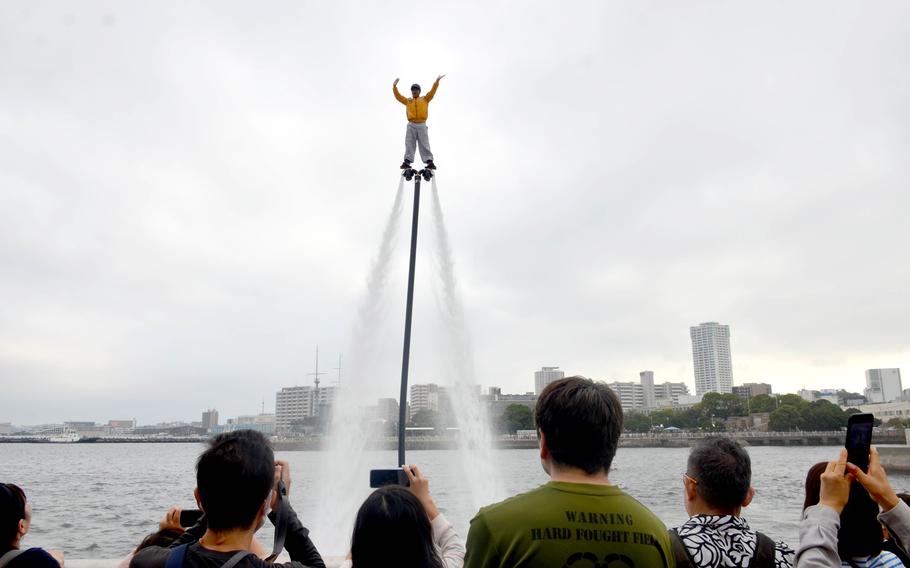 A performer on a hydroflight board shows off for the crowd at Yokosuka Naval Base.