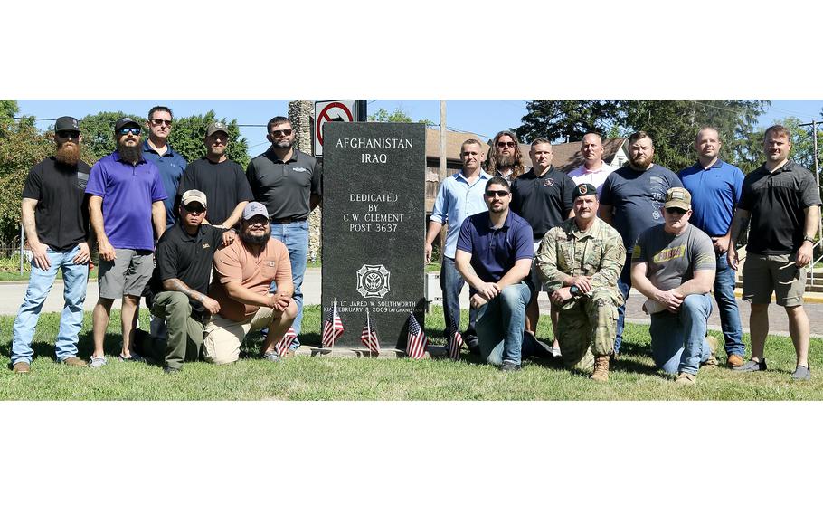 Soldiers and retirees who served with 1st Lt. Jared Southworth gather around a monument with his name after a ceremony on July 6, 2024, dedicating a section of State Highway 133 through Oakland, Ill.