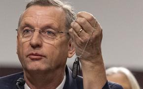 Close-up view of Doug Collins holding up a set of dogtags on a chain.