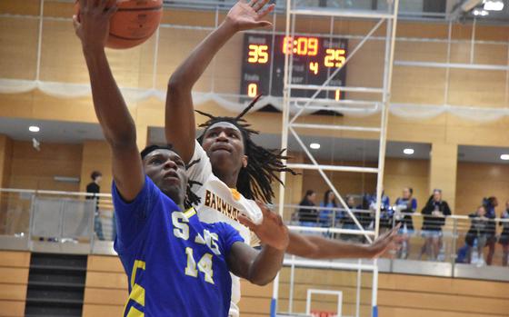 Sigonella's Mikari Spencer goes up for a layup Wednesday, Feb. 12, 2025, but Baumholder's Keo Kirkland has other ideas on the opening day of the DODEA-Europe Division III boys basketball championships in Wiesbaden, Germany.