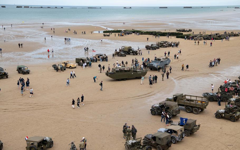People gather on the beach at Arromanches-les-Bains, France on Tuesday, June 4, 2024.