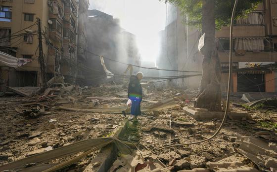 A man walks through debris from damaged buildings covering the ground in Beirut, Lebanon.