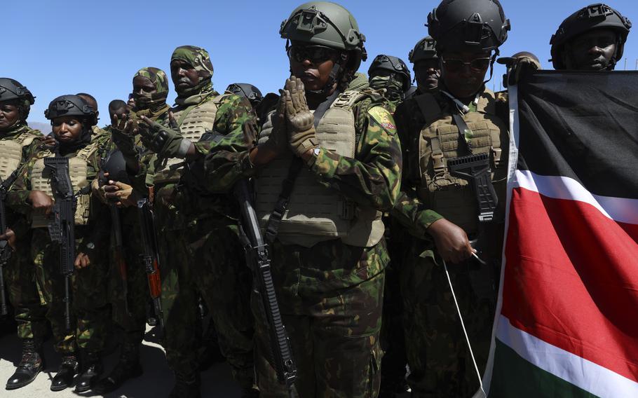 Kenyan police pray on the tarmac