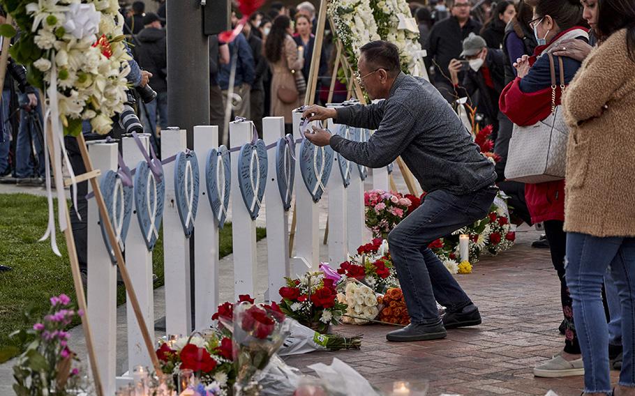 A man writes a message at a memorial in Monterey Park, Calif., on Jan. 24, 2023, after a mass killing at a dance studio. 