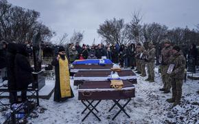 A priest blesses coffins of Kateryna Zapishnya, 38, Diana Zapishnya, 12, Danyil Zapishnyi, 8, and Serhii Zapishnyi, 40, who were killed on Feb. 1 by a Russian strike on residential building of Poltava, during a funeral ceremony in Dykanka, Ukraine, Wednesday, Feb. 5, 2025. (AP Photo/Evgeniy Maloletka)