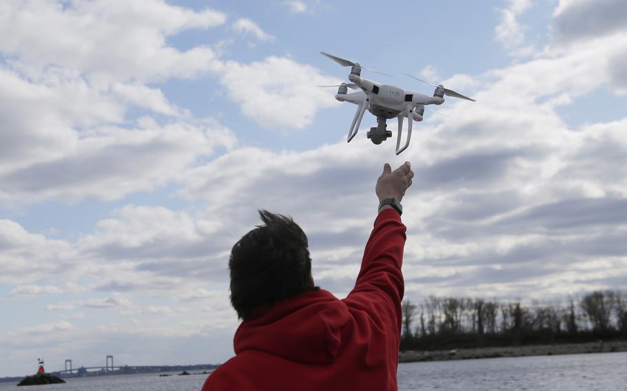 In this April 29, 2018, file photo, a drone operator helps to retrieve a drone after photographing over Hart Island in New York.