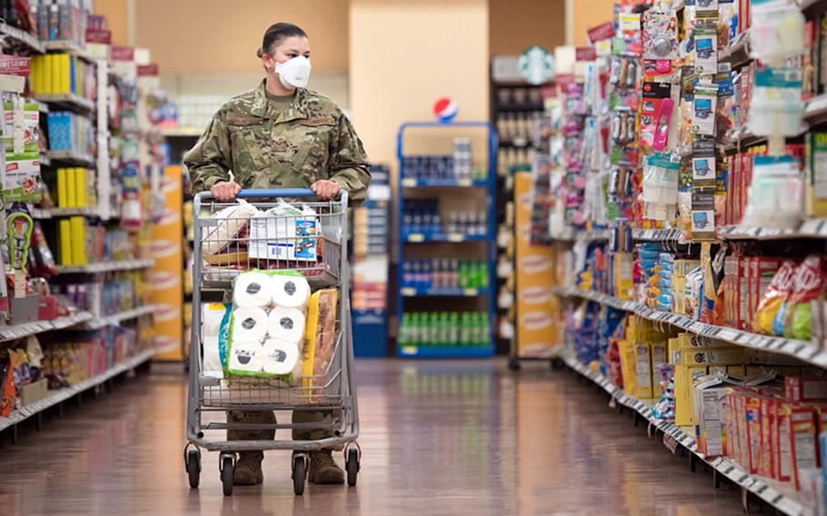 An airman shops at the RAF Mildenhall, England, commissary. The base is requiring masks to be worn indoors by all, including the fully vaccinated, following a Defense Department directive mandating them where there is "substantial or high community transmission" of the coronavirus. 