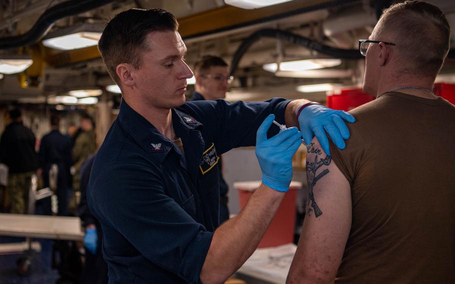 Petty Officer n 3rd Class Coltin Russel, from Gonzales, Texas, administers flu shots on the aircraft carrier USS Nimitz at Naval Base Kitsap-Bremerton, Washi., Oct. 11, 2023.